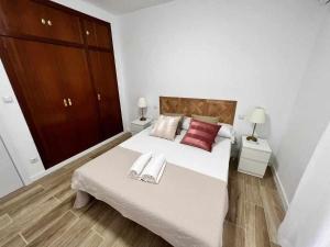1 dormitorio con 1 cama grande y 2 toallas. en Apartamenticos Libertad I, en Zaragoza