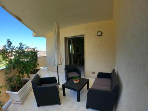 a patio with two chairs and a table and a umbrella at Maison Carmela in Monopoli