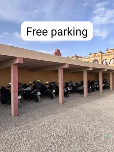 een rij motorfietsen geparkeerd op een parkeerplaats bij Traditional Riad Merzouga Dunes in Merzouga