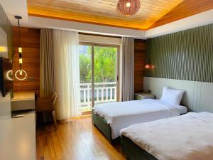 een hotelkamer met 2 bedden en een raam bij Cirali Hera Hotel in Cıralı