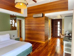 1 dormitorio con 1 cama y pared de madera en Cirali Hera Hotel, en Cıralı