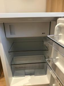 an empty refrigerator with its door open in a kitchen at Zimmerding in Erding