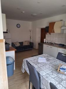 eine Küche und ein Wohnzimmer mit einem Tisch im Zimmer in der Unterkunft Zirnberg Appartements in Flattach