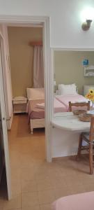 a bedroom with two beds and a mirror at Krinelos Rooms in Skala Eresou