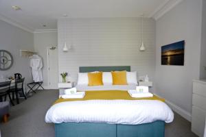 een slaapkamer met een groot bed met gele kussens bij The Dolphin Hotel Exmouth in Exmouth