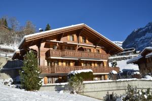 a large wooden building with snow on the ground at Apartment Chamonix - GRIWA RENT AG in Grindelwald +8 photos