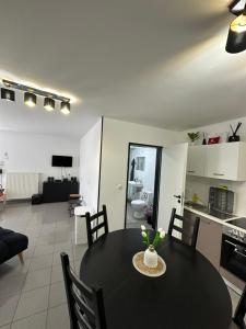 uma cozinha e uma sala de jantar com uma mesa preta e cadeiras em Ferienwohnung Sindorf em Kerpen