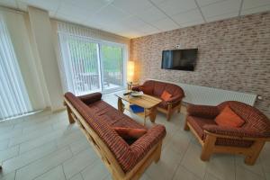 ein Wohnzimmer mit zwei Stühlen und einem Tisch und einem Fernseher in der Unterkunft Barrierefreie 6 Personen Ferienwohnung im Landhausstil in Cochem