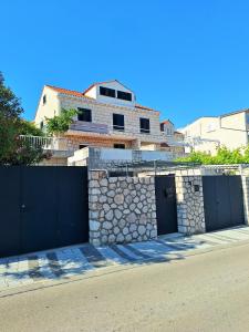 a building with two garage doors and a stone wall at Villa Blue Promenade in Dubrovnik