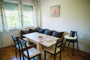 a dining room with a table and chairs and a couch at Rozina by RV Apartments in Kazanlŭk +8 photos