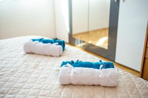 a pair of towels on a bed in a room at Rozina by RV Apartments in Kazanlŭk