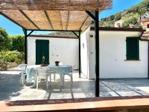 a patio with a table and chairs under a pergola at La Cicocca in Portoferraio