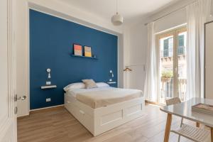- une chambre bleue avec un lit et un mur bleu dans l'établissement Sant'Agostino Apartment with Terrace by Wonderful Italy, à Palerme