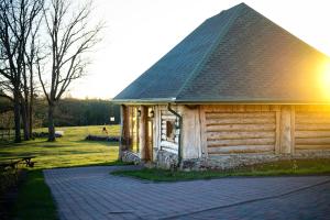 Cabaña de madera pequeña con techo de gambrel en Metsapiiga Puhkemaja, 