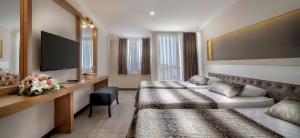 a hotel room with two beds and a flat screen tv at Rox Resort Hotel in Kemer
