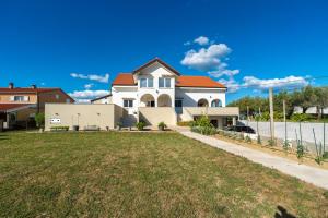 a large white house with an orange roof at Ema's Olive Garden Apt 2 -private parking, 10 min drive from sandy beach in Poličnik