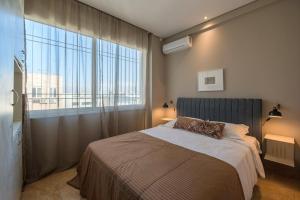 um quarto com uma cama e uma grande janela em Holodek Apartments Ippokratous em Atenas