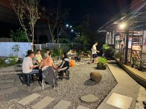 a group of people sitting around a patio at night at 1796花點時間風呂會館 in Toucheng