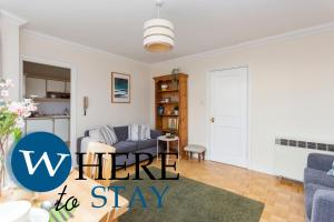 un soggiorno con divano blu e tavolo di Bright 1 Bedroom Apartment-Private PARKING a Glasgow