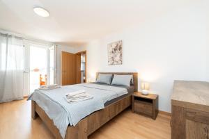 a bedroom with a large bed and a window at Ema's Olive Garden Apt 2 -private parking, 10 min drive from sandy beach in Poličnik