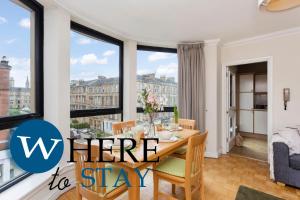 a dining room with a table with a view of the city at Bright 1 Bedroom Apartment-Private PARKING in Glasgow