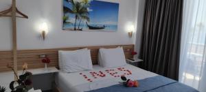 a hotel room with a bed with red letters on it at Anxhelos Hotel in Himare