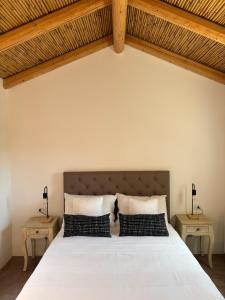 a bedroom with a large white bed with two tables at Alora boutique suites in Lecce