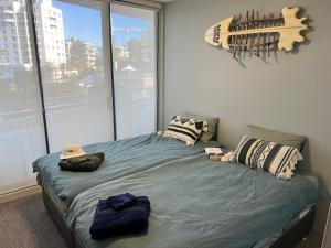 a bedroom with a bed with a large window at Ocean View Private Cronulla Apartment in Cronulla +22 photos