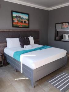 a bedroom with a large bed with white sheets at Kgakgamela road lodge in Driekop