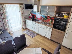 a kitchen with white cabinets and a stove top oven at Apartment Rupertus-4 by Interhome in Maishofen