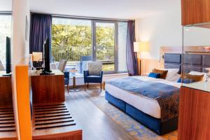 ein Hotelzimmer mit einem Bett und einem Balkon in der Unterkunft FAVORITE Parkhotel in Mainz