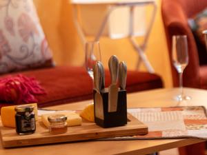 une planche à découper avec des couteaux et du fromage sur une table dans l'établissement Holiday Home Schäfer by Interhome, à Norden
