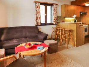 sala de estar con sofá y mesa con un bol de fruta en Apartment Les Arsets 301-11 by Interhome, en Arveyes