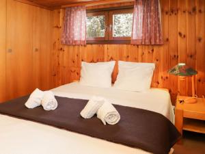 Un dormitorio con una cama con toallas. en Apartment Les Arsets 301-11 by Interhome, en Arveyes