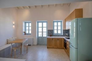 a large kitchen with a table and a refrigerator at Nerofaoma House in Dhriopís