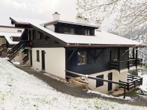 a house with a black and white facade in the snow at Apartment Les Arsets 301-11 by Interhome in Arveyes