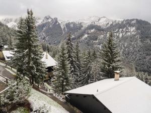 a snow covered mountain with a house and trees at Apartment Les Arsets 301-11 by Interhome in Arveyes +21 photos