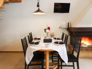 een tafel met stoelen en een open haard in een kamer bij Apartment Les Arsets 301-11 by Interhome in Arveyes