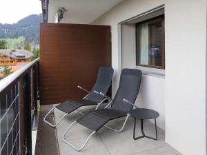 3 sedie sedute su un balcone con finestra di Apartment Gamat 30 by Interhome a Villars-sur-Ollon