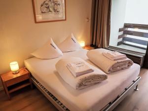 1 dormitorio con 1 cama con toallas en Apartment Utoring Acletta-125 by Interhome, en Disentis
