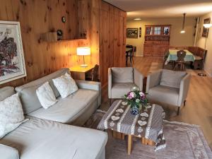 un soggiorno con divano, tavolo e sedie di Apartment Utoring Acletta-125 by Interhome a Disentis