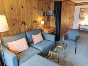 sala de estar con sofá azul y silla en Apartment Utoring Acletta-48 by Interhome, en Disentis