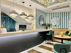 バルセロナにあるITC Barcelona By Soho Boutiqueの青と白の縞模様の壁とテーブルと椅子のあるロビー