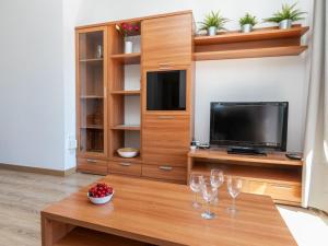 a living room with a tv and wine glasses on a table at Apartment Eixample Esq Rocafort Diputacio by Interhome in Barcelona