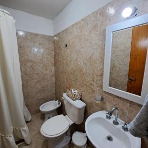 a bathroom with a toilet and a sink and a mirror at Alquiler temporario - NG in Resistencia +4 photos