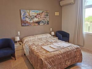 una camera con un letto e due sedie blu di Hotel Castellverd a Vinarós