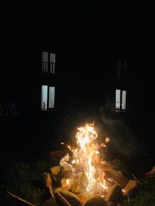 Ein Feuer brennt nachts vor einem Gebäude in der Unterkunft Altay Village Hotel 
