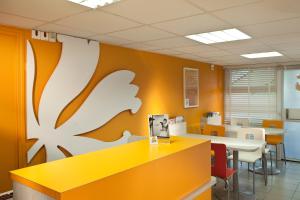 um escritório com uma parede amarela e branca em Premiere Classe Lille Nord Roncq em Roncq