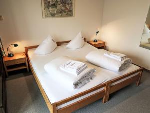 uma cama com lençóis brancos e almofadas em Apartment Utoring Acletta-120 by Interhome em Disentis