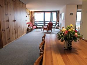 een kamer met een tafel met een vaas met bloemen erop bij Apartment Utoring Acletta-120 by Interhome in Disentis
